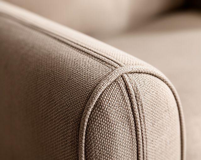 Close-up of a sofa arm after cleaning with restored fabric tone and crisp seam detail